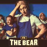Imagem promocional da série The Bear, com os personagens principais em destaque, usando uniformes de cozinha, em frente a um cenário urbano que remete a Chicago. O protagonista aparece ao centro, com expressão cansada e mão na cabeça.