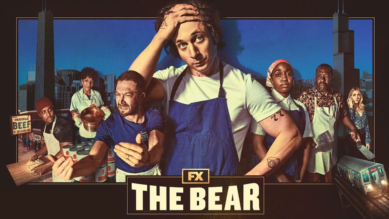 Imagem promocional da série The Bear, com os personagens principais em destaque, usando uniformes de cozinha, em frente a um cenário urbano que remete a Chicago. O protagonista aparece ao centro, com expressão cansada e mão na cabeça.